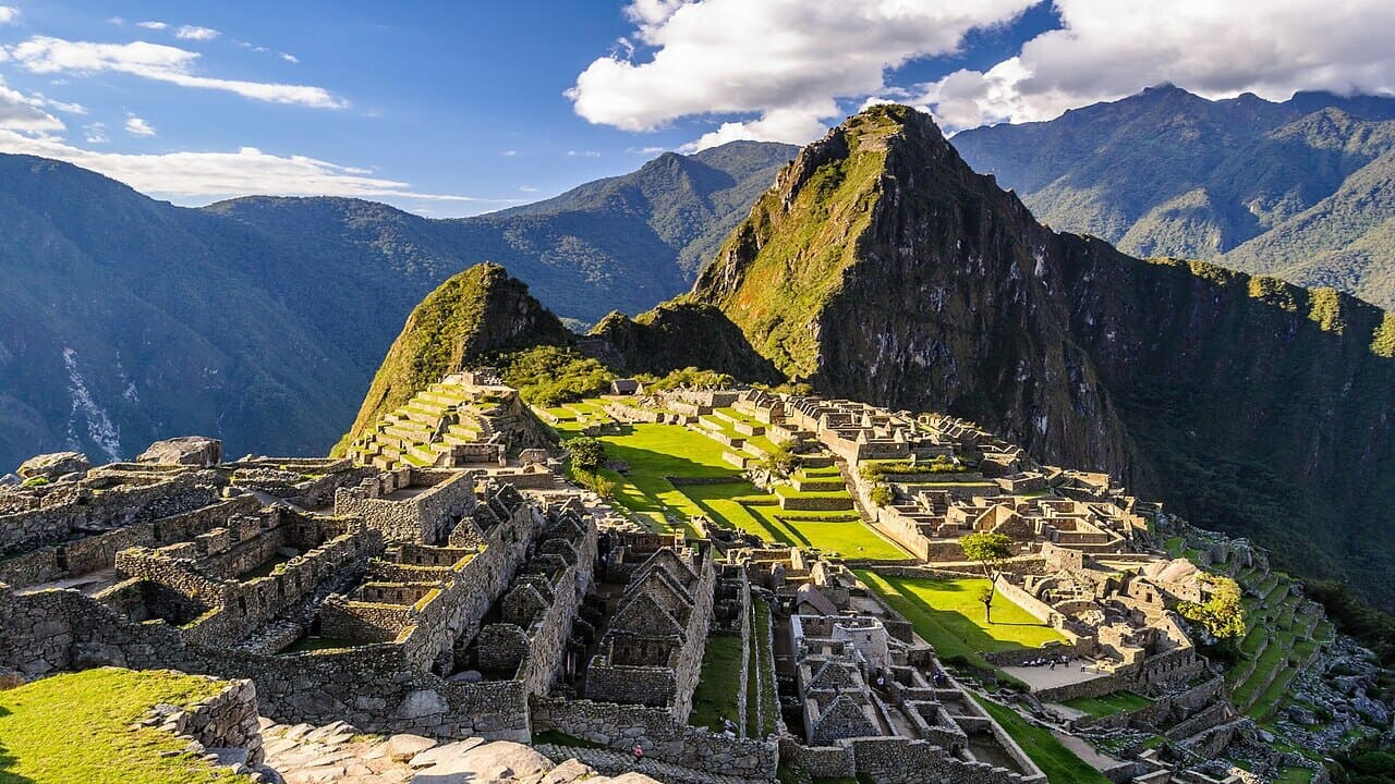 Vista panorámica de las ruinas incas de Machu Picchu en Perú con la montaña Huayna Picchu al fondo.