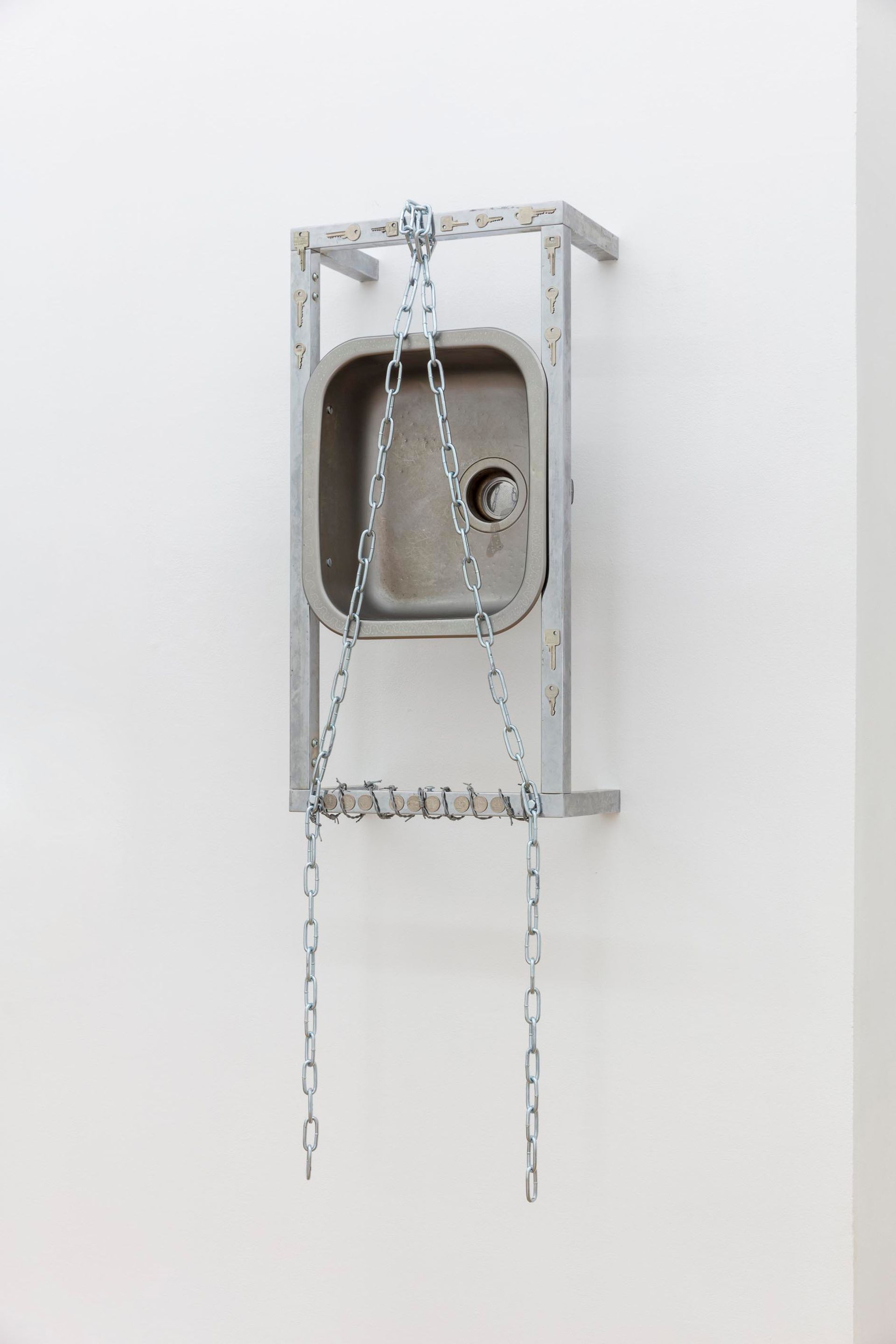 Anna McCarthy, “Shackles / Kitchen”, 2022, stainless steel, chrome, leather, coins, glue, bolts, wire, keys, 145 × 44.5 × 26.5cm