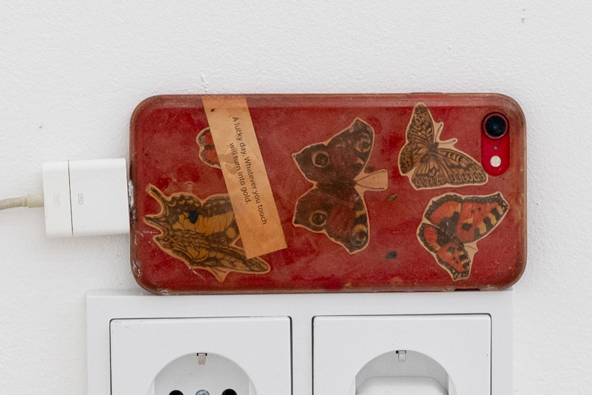 Anna McCarthy, Butterfly Phone, 2025, iPhone, stickers, charger, 13 × 7 × 1 cm, dimensions variable