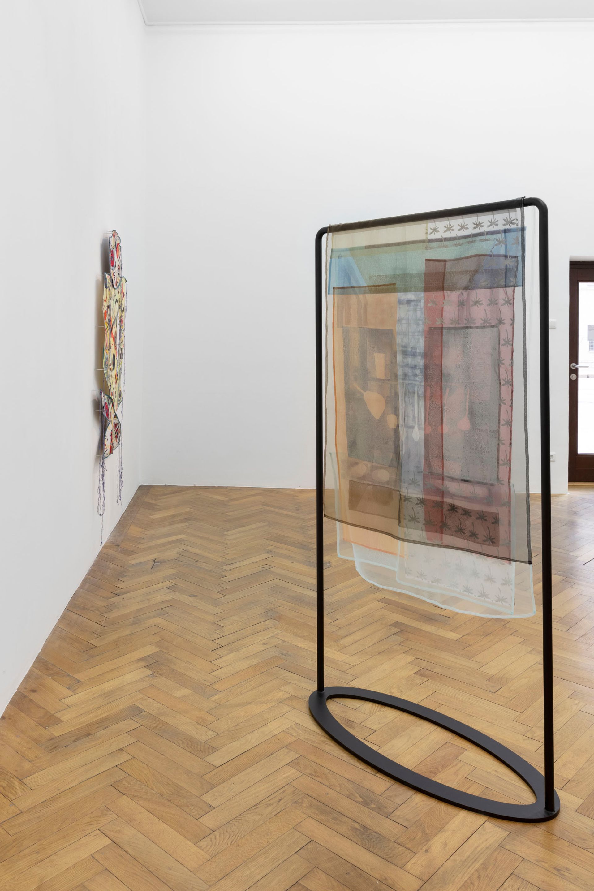 Ana Navas, Group using triangle, 2021, Silkscreen on translucent textile and metal stand, 187 × 110 × 45 cm