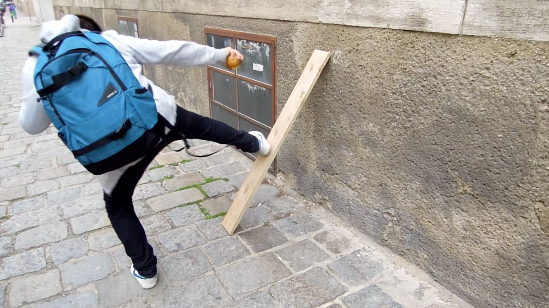 Das Brett, 2014, video, 1:15 min. Three kids trying to kick through a blank which leans against a house wall.