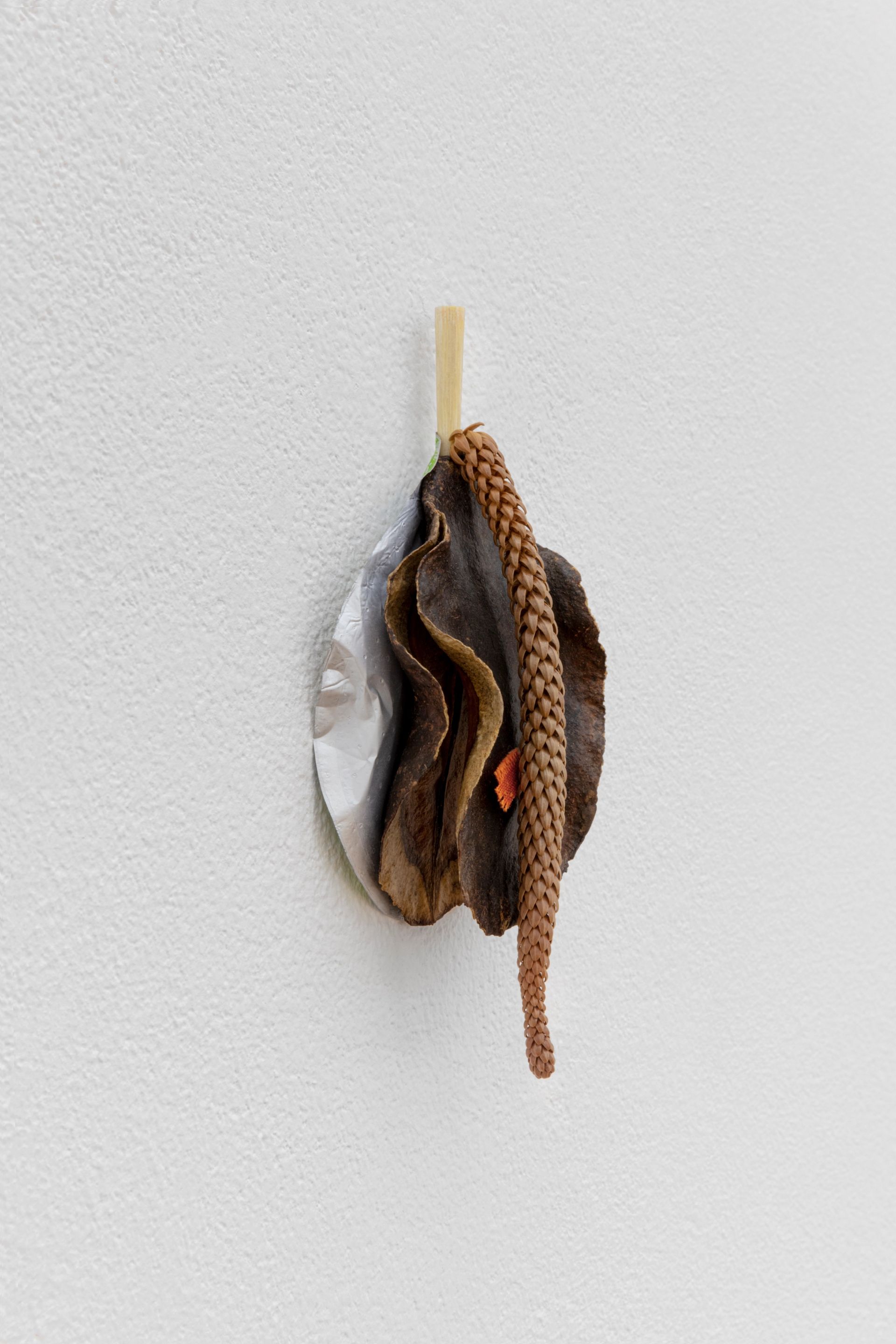 David Fesl, Untitled, 2022, Aluminum yogurt cup lid, bamboo chopstick, dried seeded fruit, parasitic plant, cloth, 13.9 × 6.4 × 2.9 cm, photo: Sebastian Kissel
