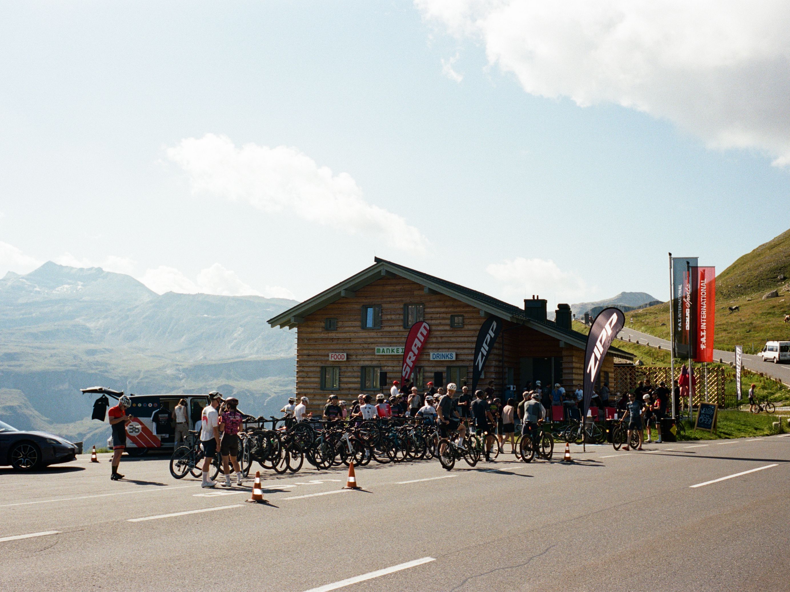 The FAT Mankei Hütte atop the Grossglockner, on a sunny day with a nice group of cyclists filling the parking spaces