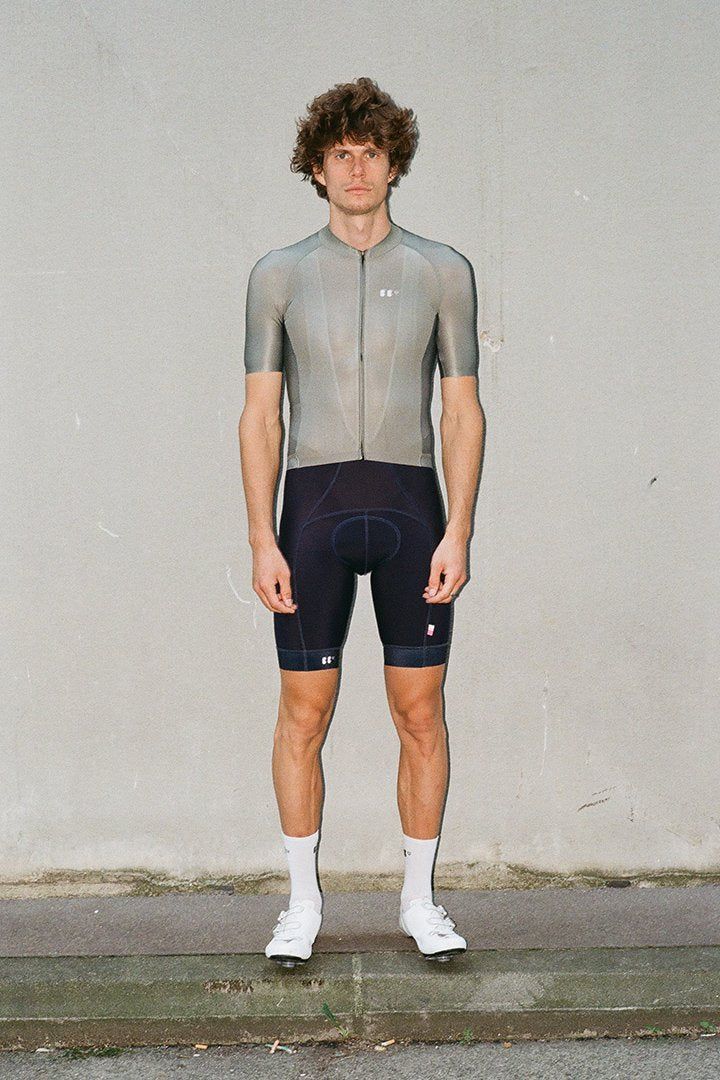 portrait of stephan along the sidewalk, wearing everyday olive jersey and dance bibs in navy