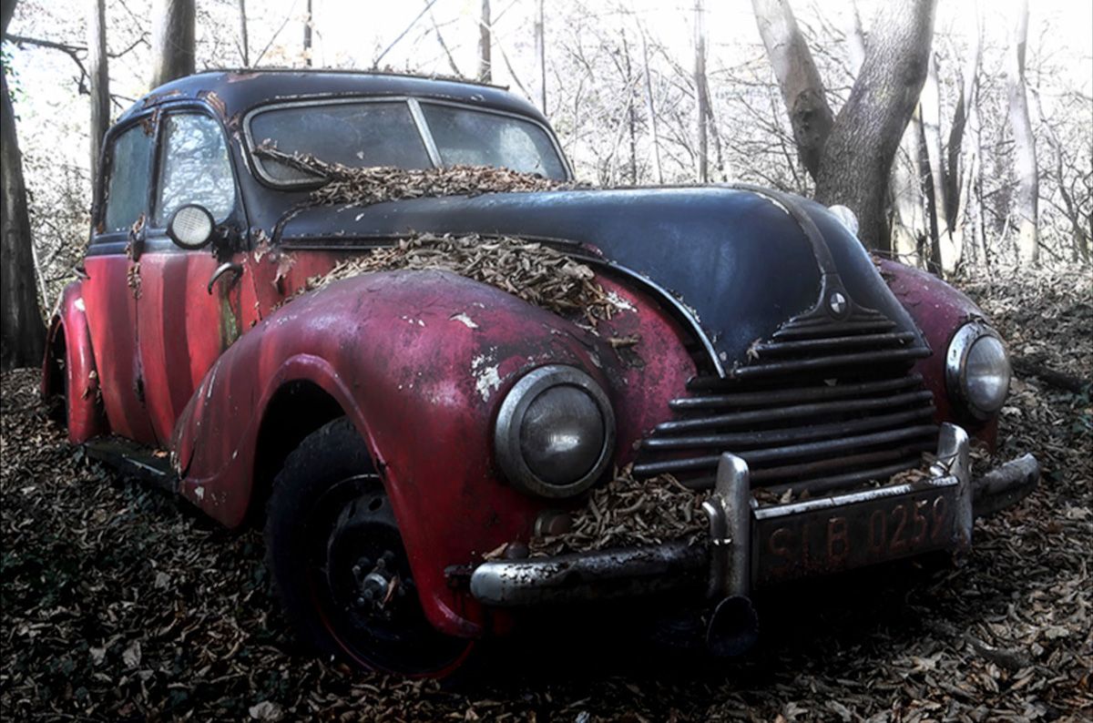 Martina Chardin Fotografia vecchia auto d'epoca rossa abbandonata nella foresta