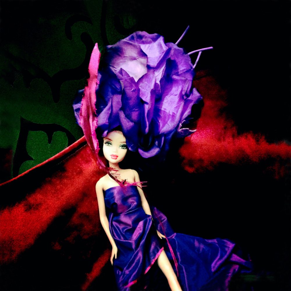 迪莉娅-迪克曼摄影 芭比娃娃在红色天鹅绒背景前，穿着紫色的蓝色裙子，戴着巨大的紫色头巾，摆出各种姿势。