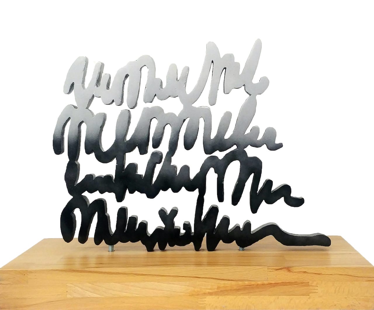 Scultura tipografica di Val Wecerka in alluminio argentato con corsivo su base di legno