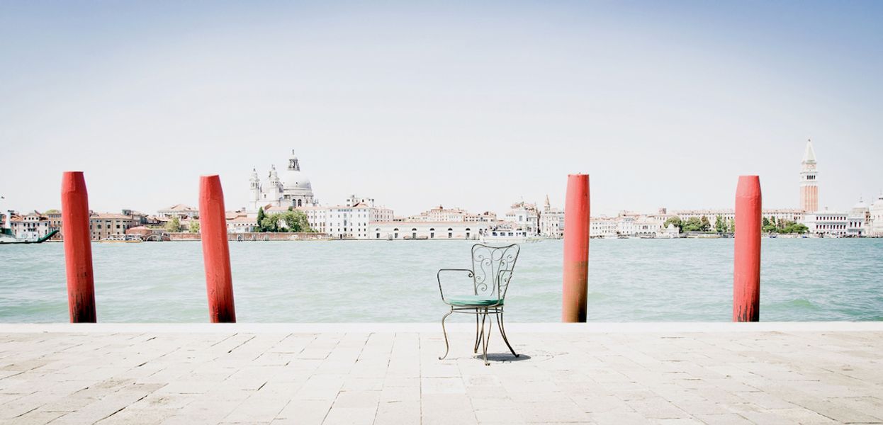 Georgia Ortner Fotografie Metall Stuhl an Docks in Venedig mit roten Pfosten