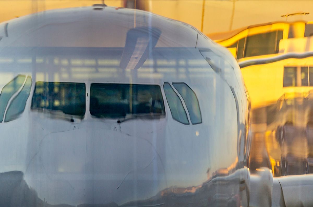 Jjoe Willems Fotografie verzerrte Spiegelung eines Flugzeugs in Glasscheibe