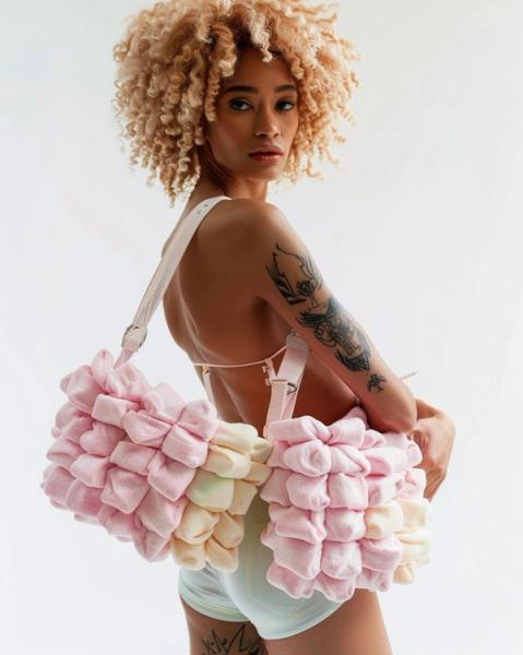 Bonny Carrera's KI generiertes Porträtbild "Marshmallows" zeigt eine Junge-Frau mit einer Marshmallow-Tasche. Die Farben sind überwiegend Rosa.