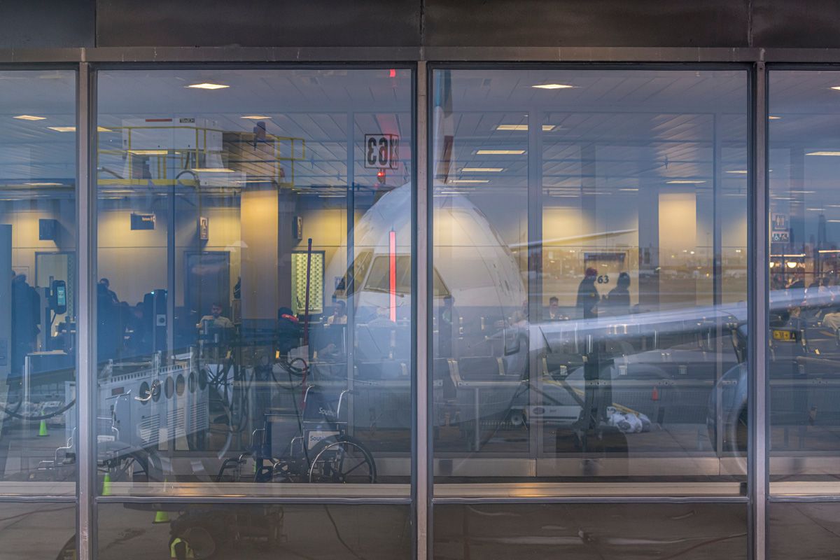 Joe Willems photographie fenêtre vue terminal d'aéroport avec grand reflet d'un avion dans les fenêtres