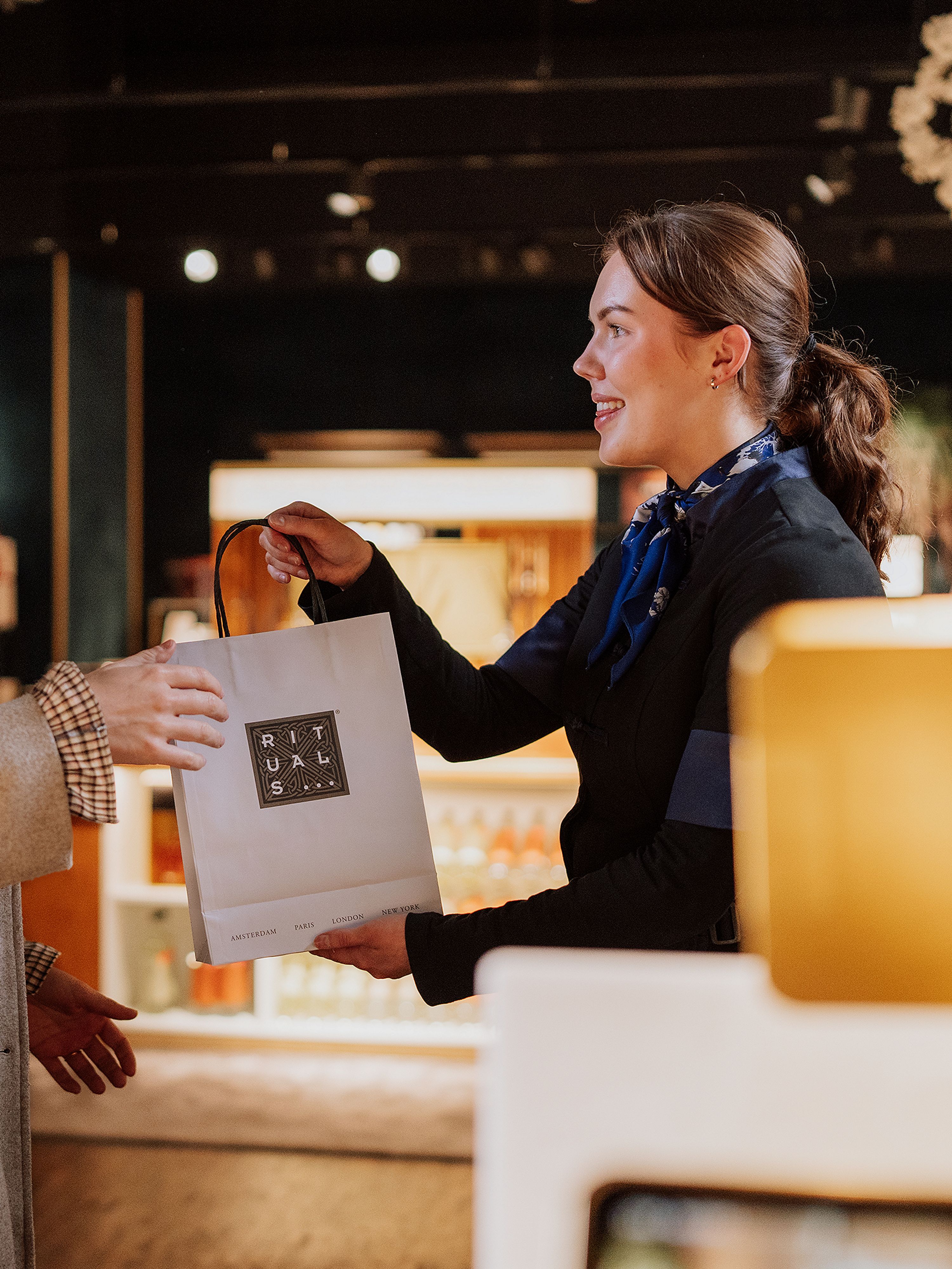 Un employé de Rituals et un client