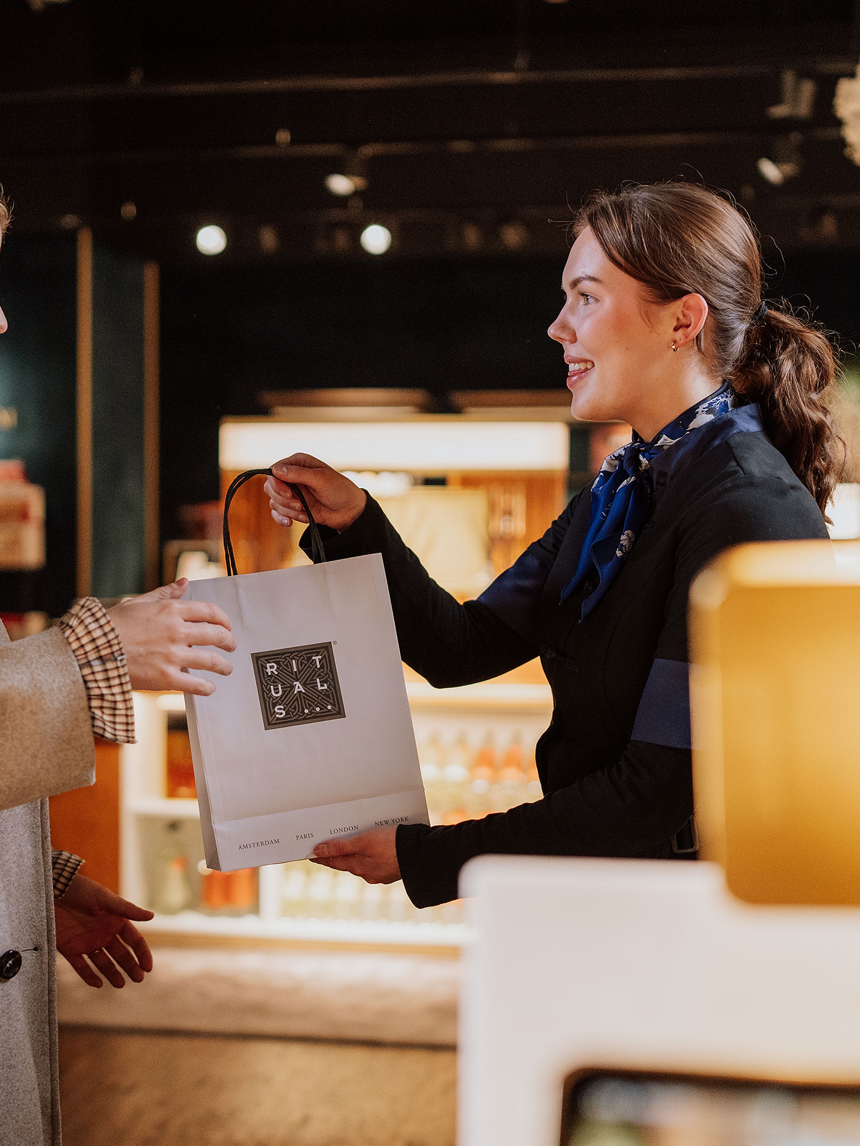 Un employé de Rituals et un client