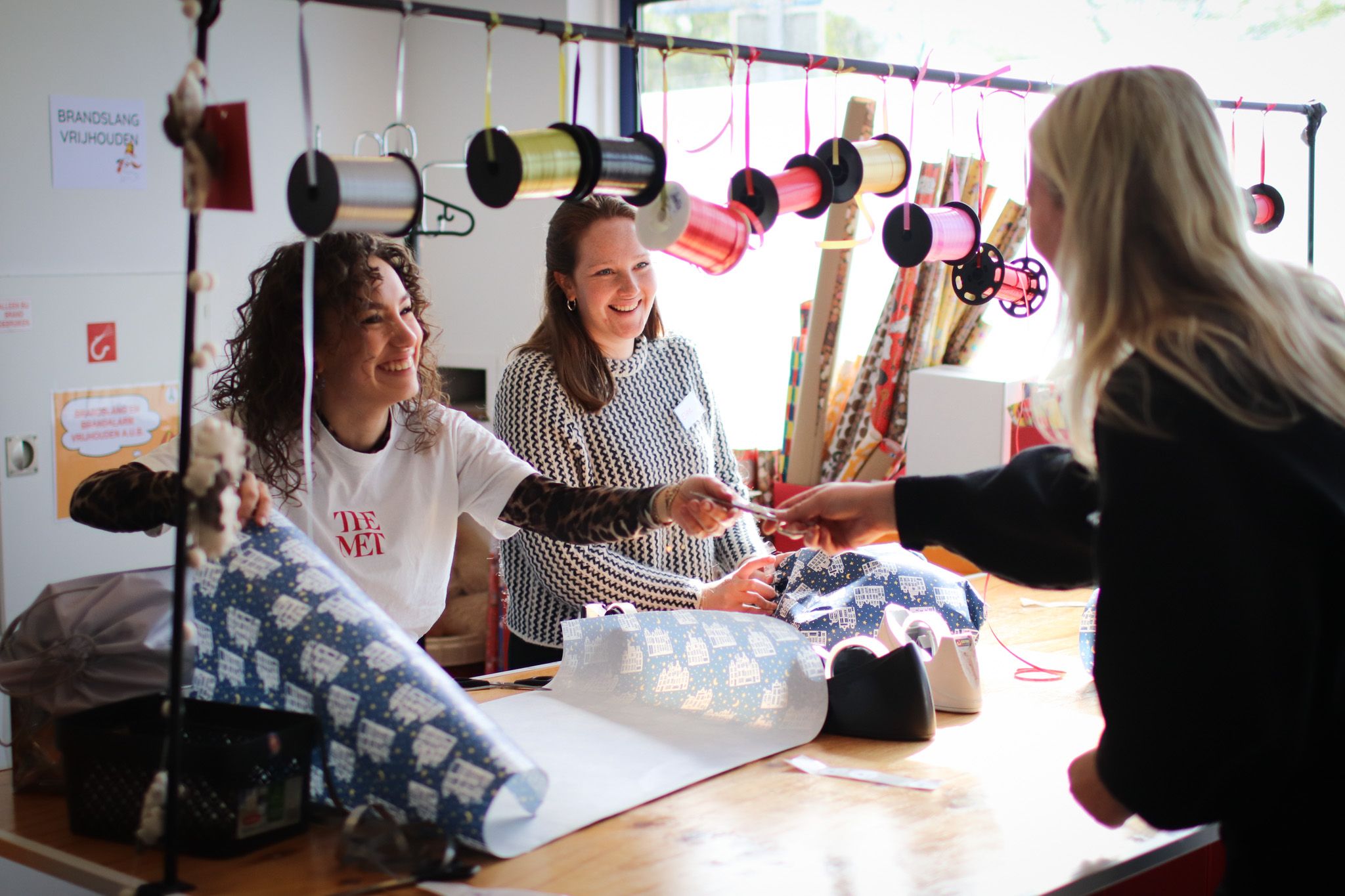 Collègues RH emballant des cadeaux et s'amusant.