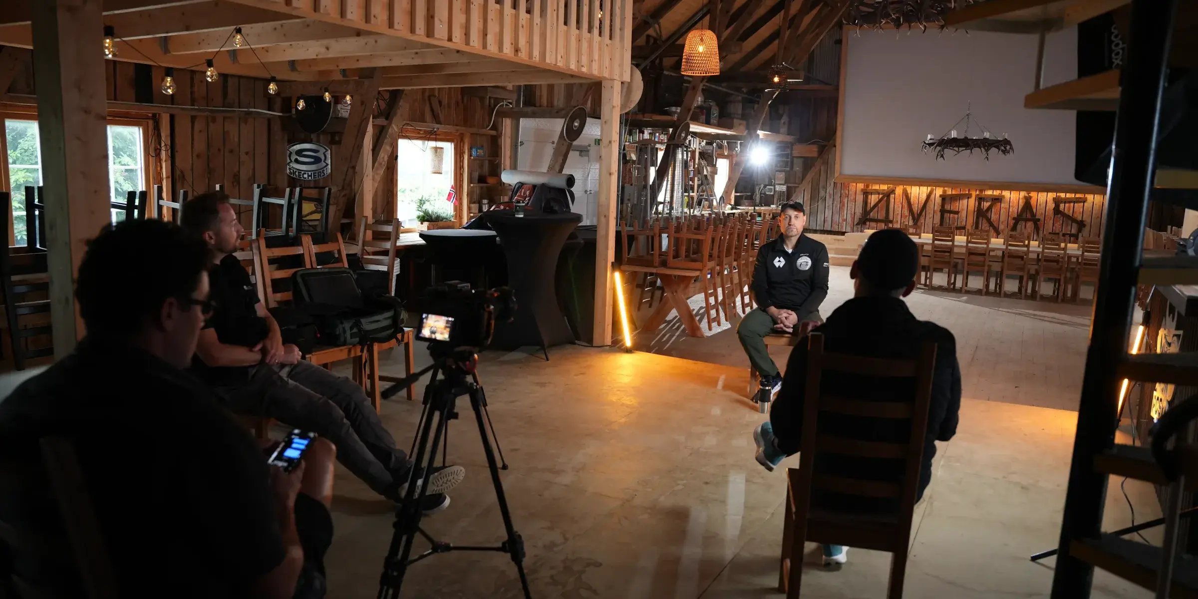 Filmimeeskond jälgib intervjuud soojas valguses küünis