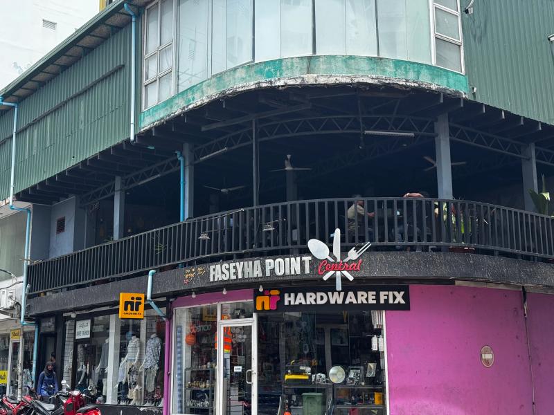 Faseyha Point Central rooftop seating sign above a Hardware Fix shop on a pink corner building