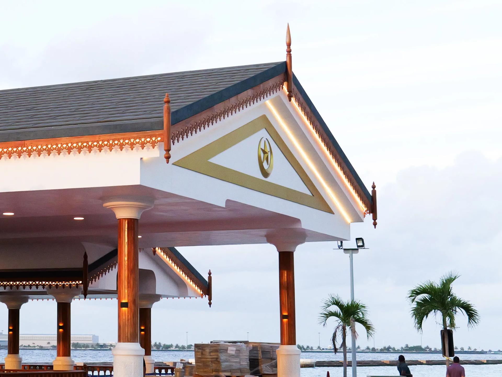 The Presidential Jetty pavilion in Malé, white with carved timber detailing and a gold crescent and star on its gable