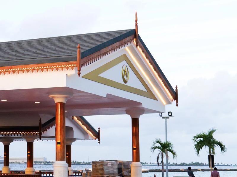 The Presidential Jetty pavilion in Malé, white with carved timber detailing and a gold crescent and star on its gable