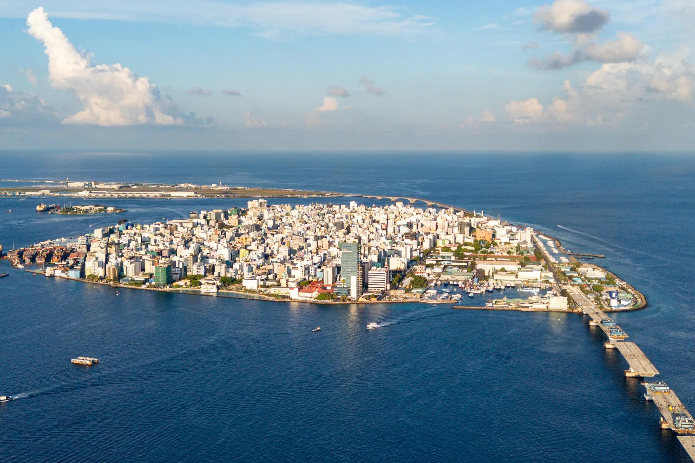 Aerial view of Malé from the sea, high-rise buildings covering the whole island