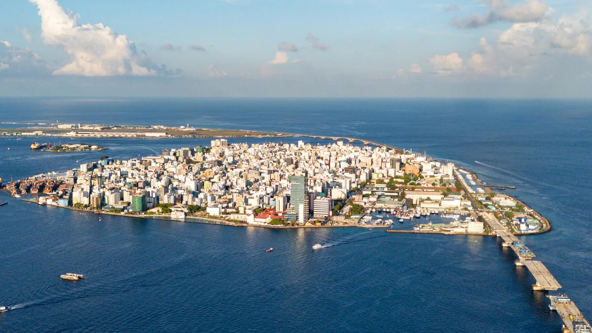 Aerial view of Malé from the sea, high-rise buildings covering the whole island