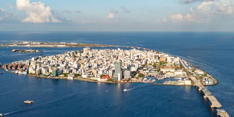 Aerial view of Malé from the sea, high-rise buildings covering the whole island