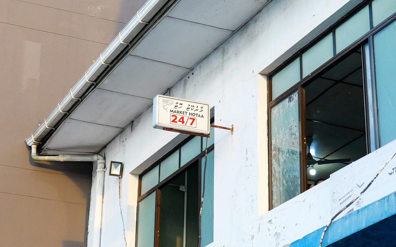 Market Hotaa 24/7 lightbox sign on the wall of the Malé Fish Market building