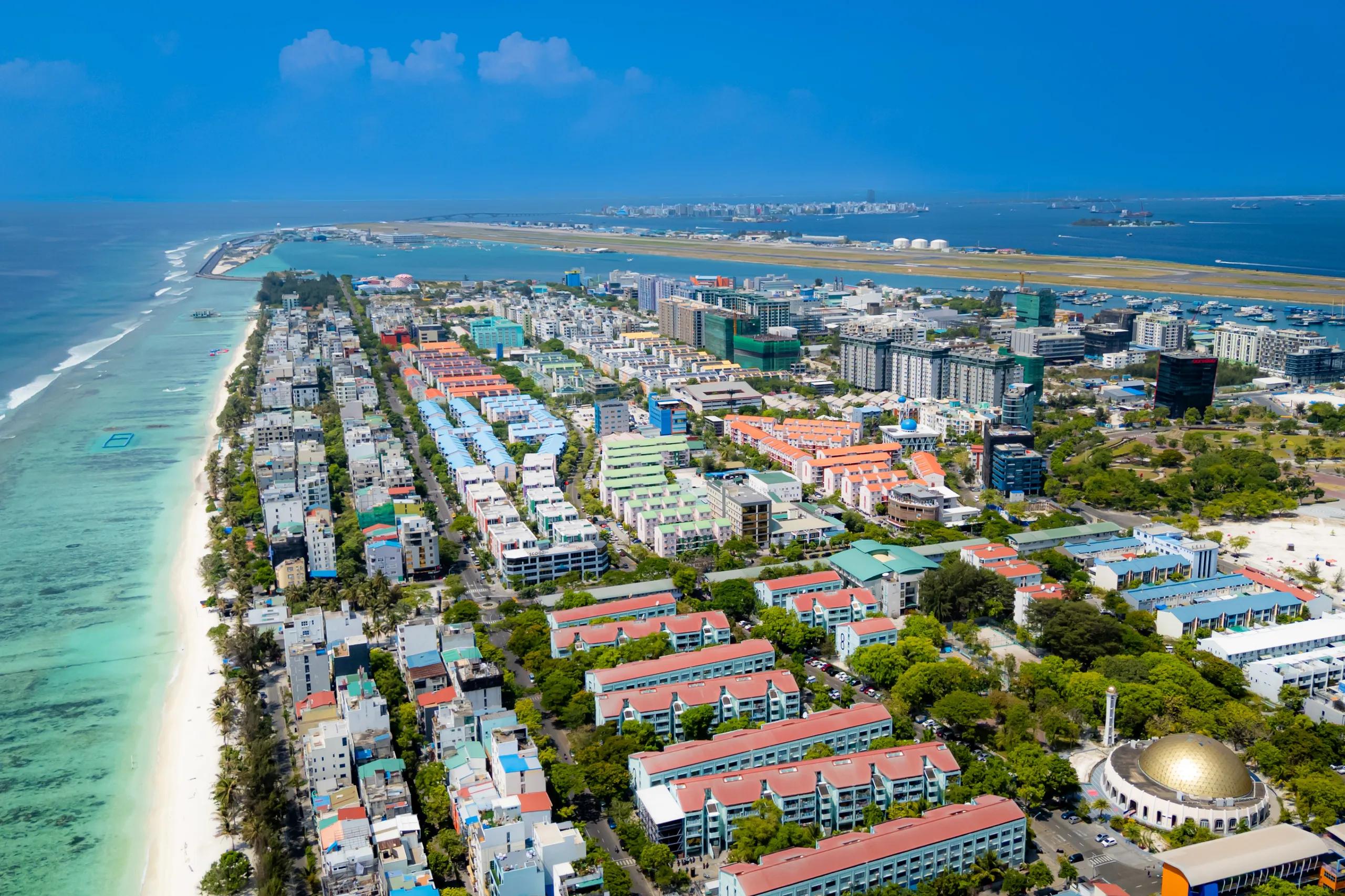 Aerial view along the Hulhumalé coastline with the airport runway in the distance