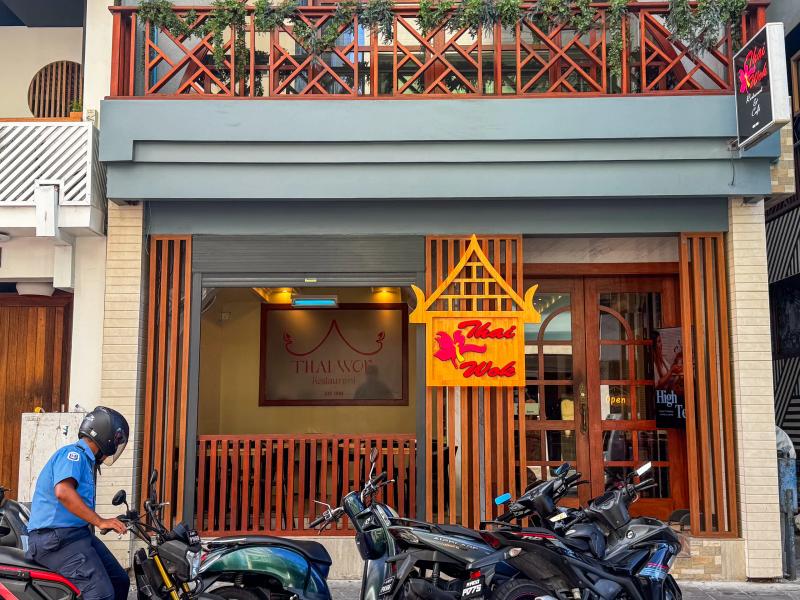 Thai Wok Restaurant's street front with red and gold Thai gable signage and a latticed timber balcony above