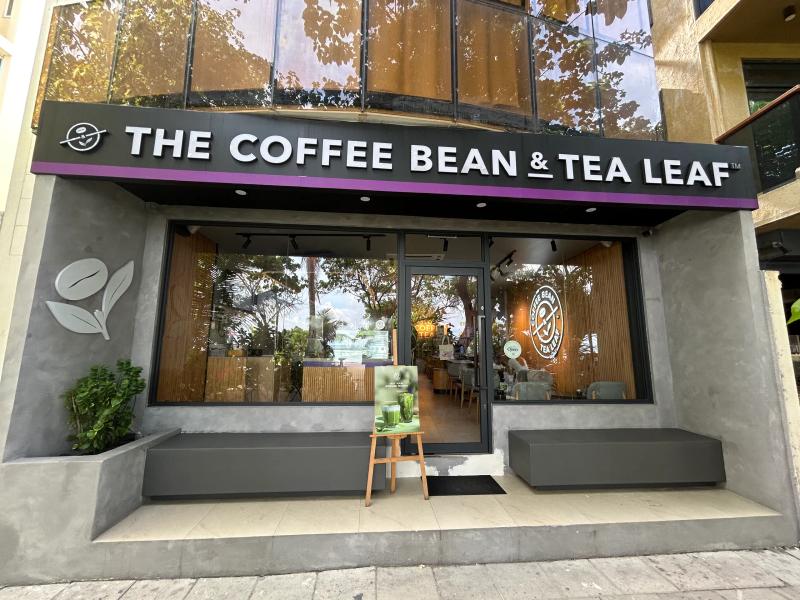 The Coffee Bean & Tea Leaf storefront with illuminated sign, glass front and grey seating benches outside