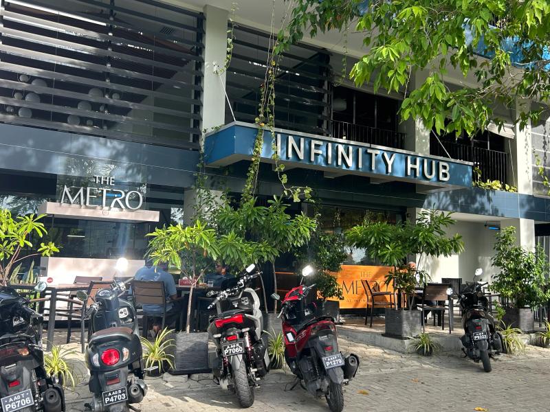 The Metro cafe at Infinity Hub, with outdoor seating, greenery and rows of parked motorcycles in front