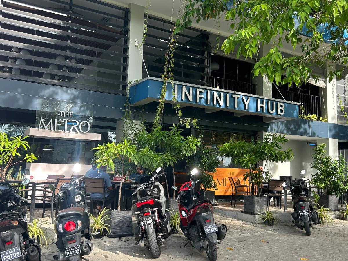 The Metro cafe at Infinity Hub, with outdoor seating, greenery and rows of parked motorcycles in front