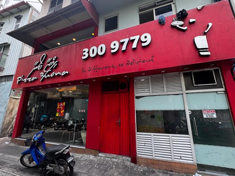 Red facade of Pizza Buona with phone number 300 9779 and the tagline so different, so delicious
