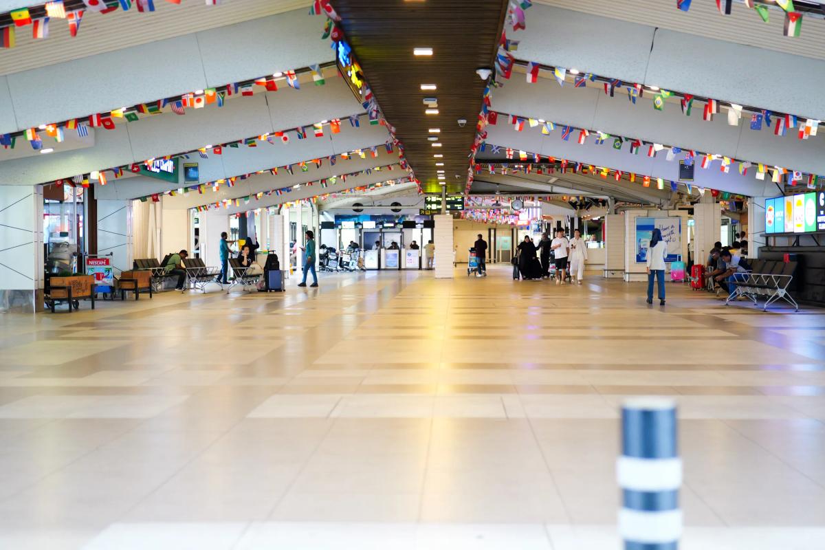 The concourse inside Terminal 2 at Velana International Airport, strung with rows of international flags