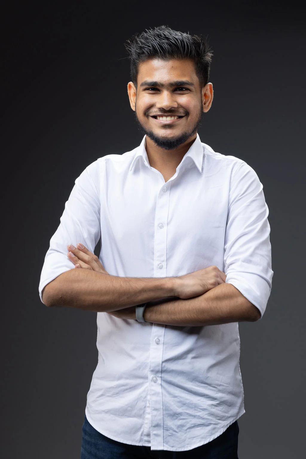 Ibrahim Faarih, founder and editor of Malé Travel Guide, smiling with arms crossed in a white shirt