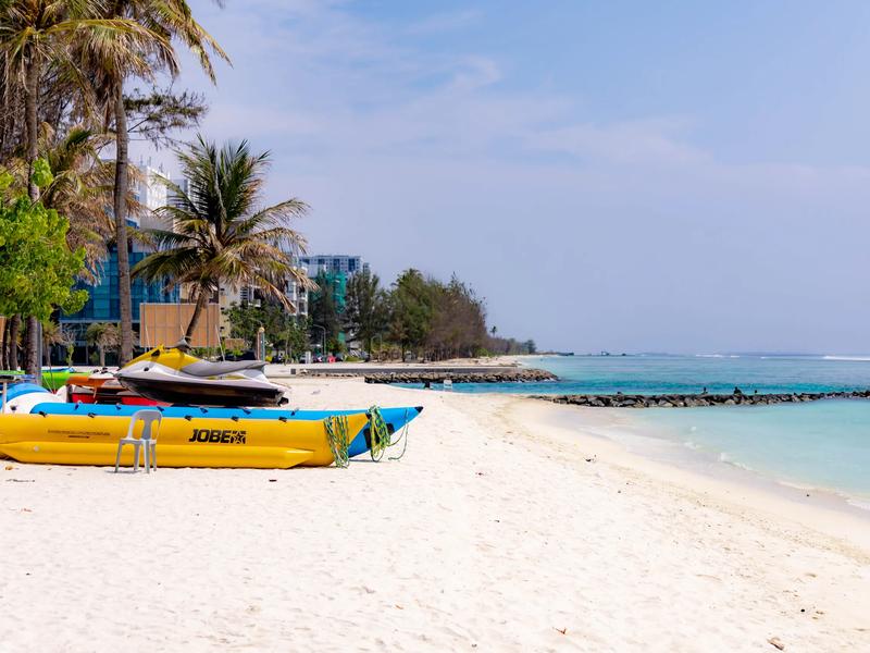Jet ski and yellow banana boat on white sand beside a turquoise lagoon at Hulhumalé Phase 1 Beach