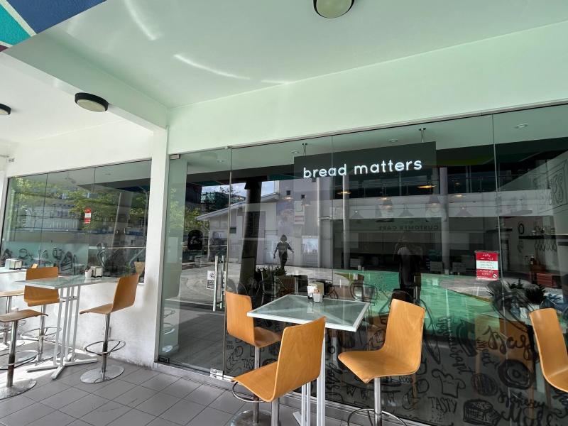 bread matters' glass-fronted cafe with high tables and stools under the covered terrace