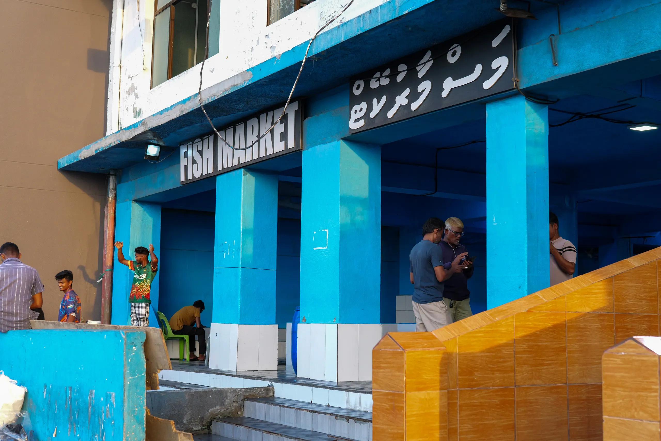Blue-columned entrance of the Malé Fish Market, with the Fish Market sign in English and Dhivehi