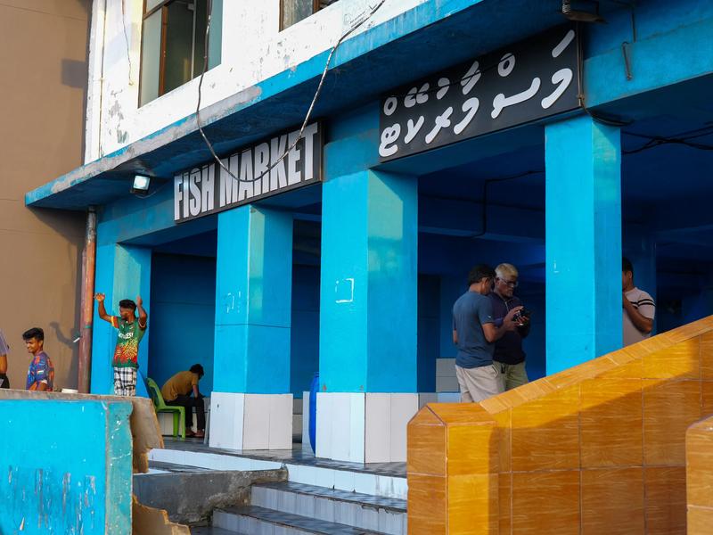 Blue-columned entrance of the Malé Fish Market, with the Fish Market sign in English and Dhivehi