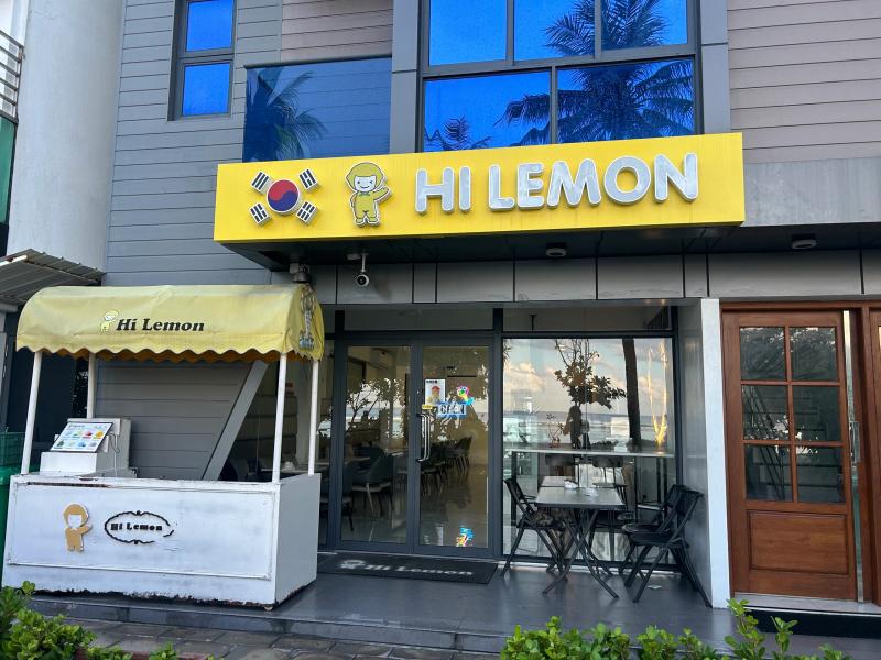 Yellow Hi Lemon signage with a Korean flag motif above a glass storefront and outdoor table