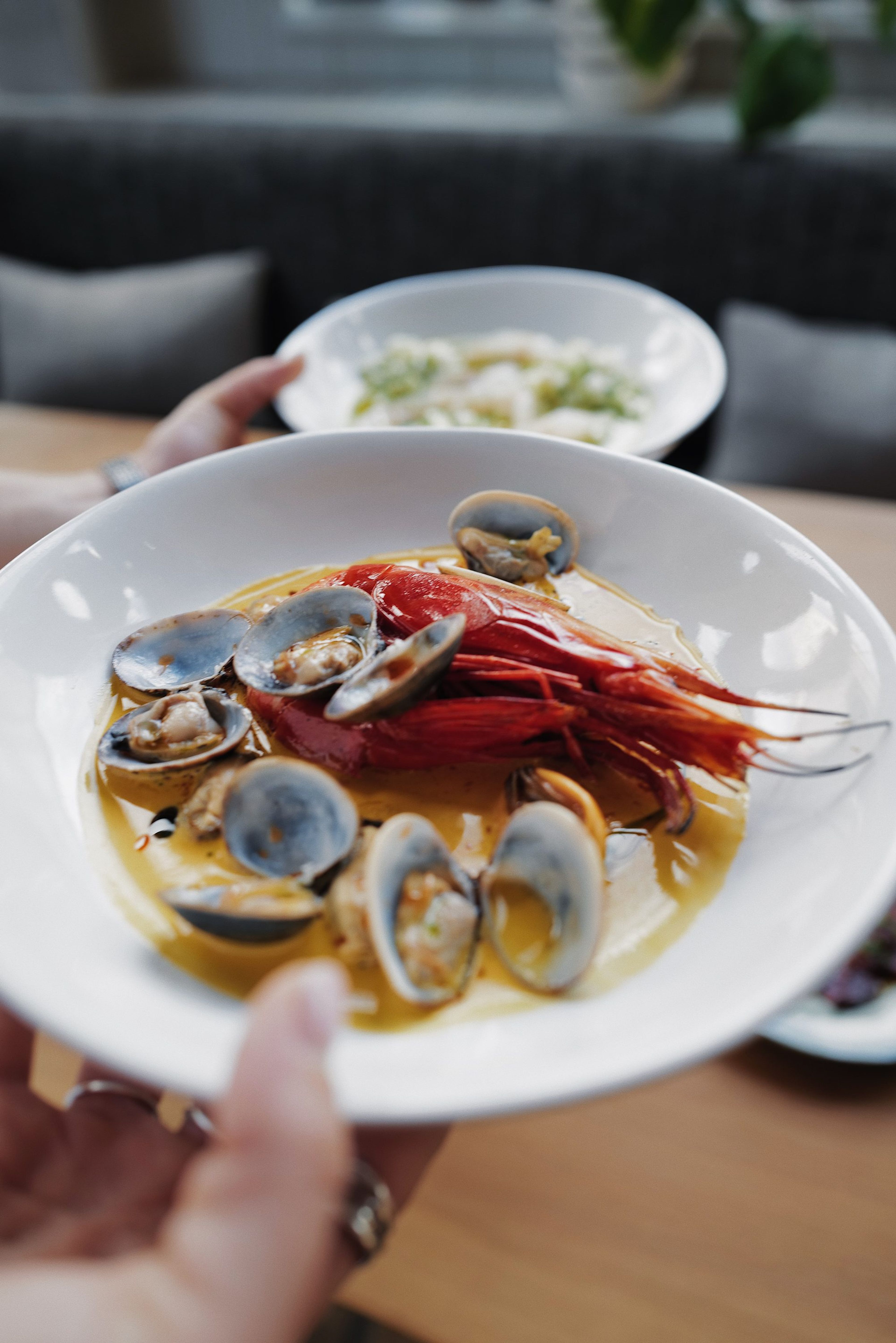 Grilled carabinero with mussels and clams, held out across the table