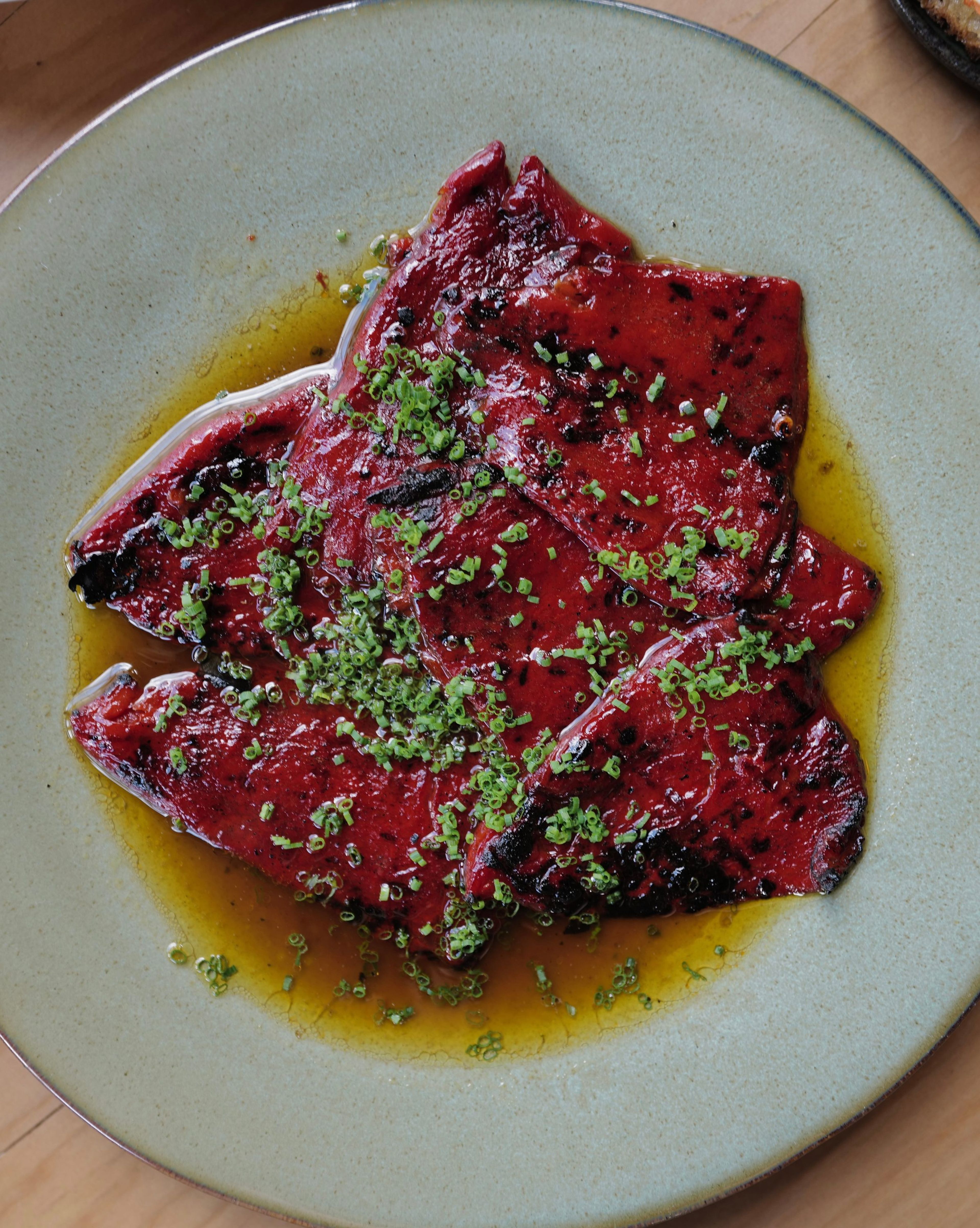Charred red peppers in olive oil with chives