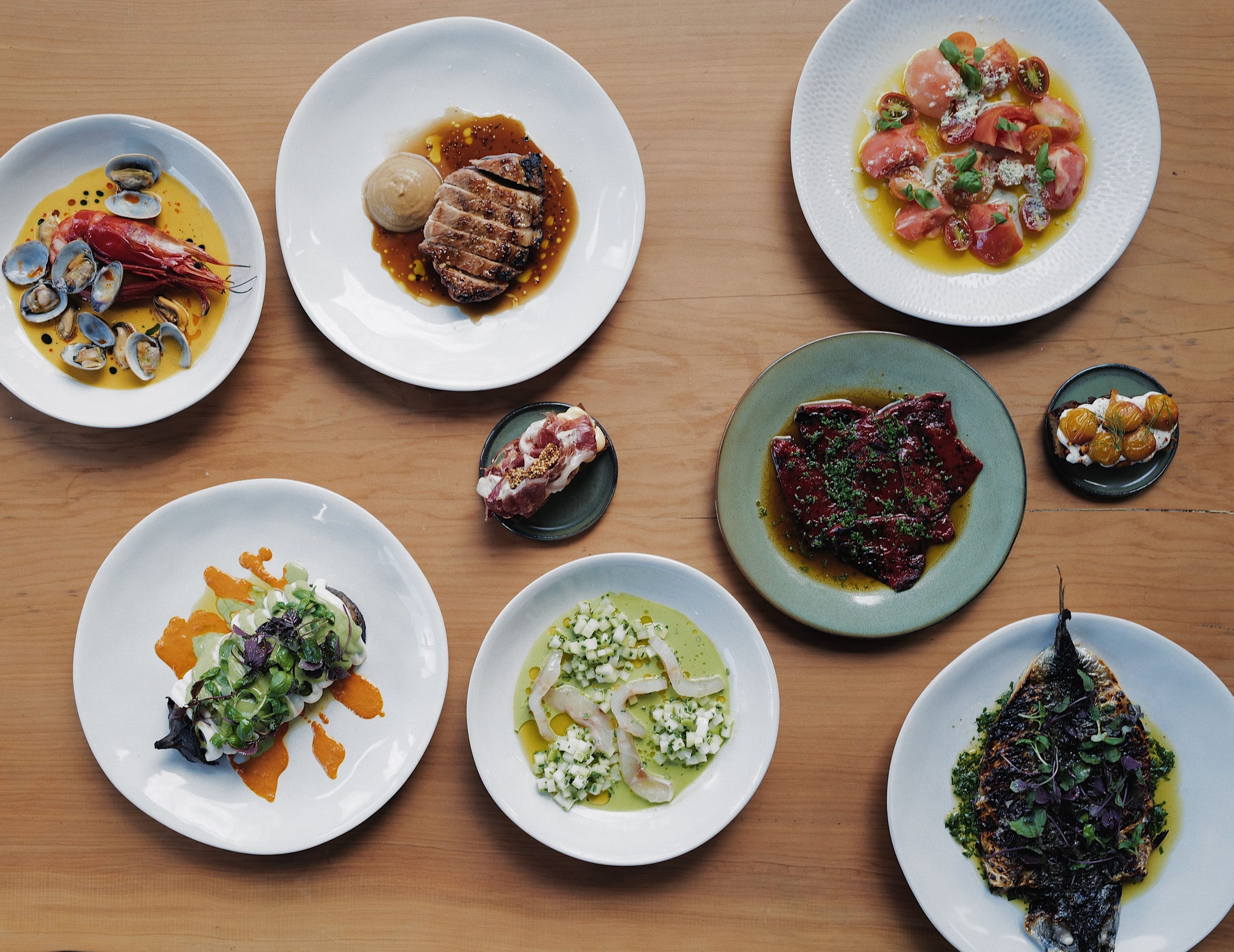 Overhead view of a spread of small plates on a wooden table