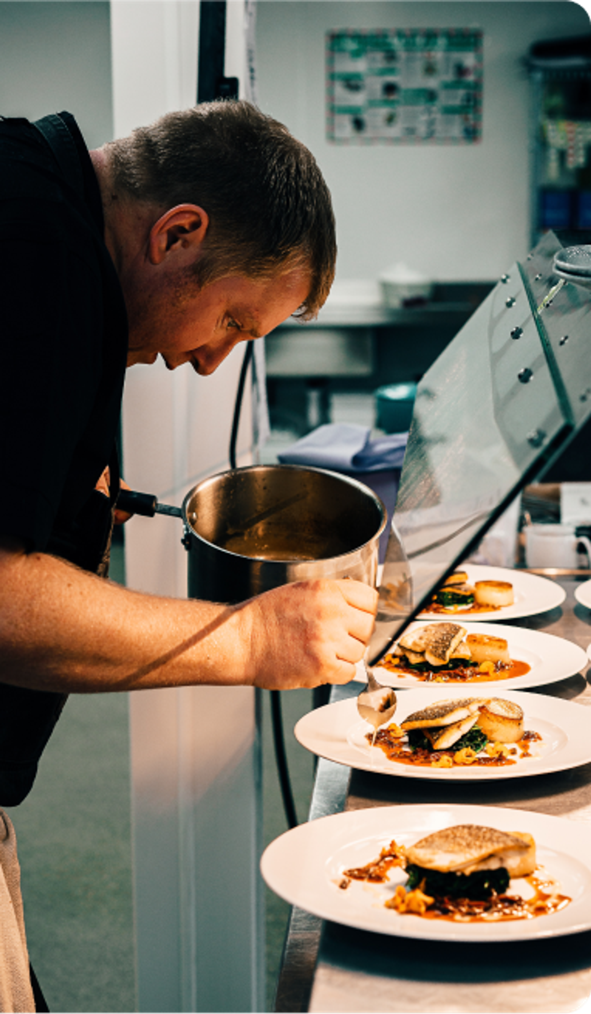 Imagem de um cozinheiro participando do processo de produção de pratos culinários.