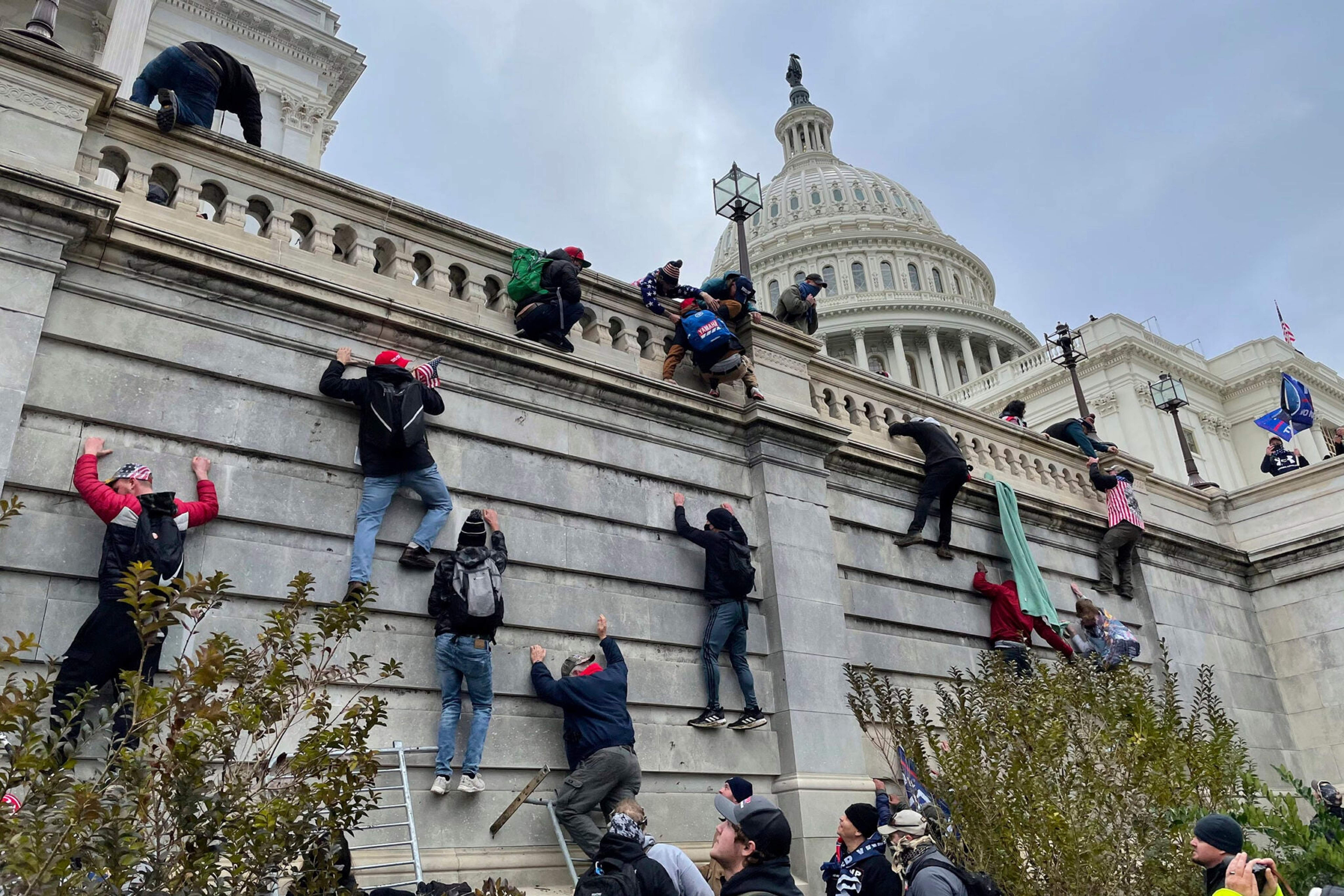 Trump supporters scale the west wall of the Capitol on January 6, 2021.