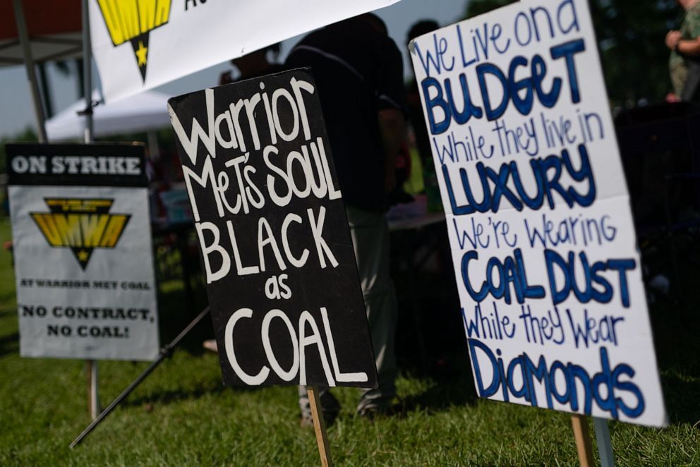 Yard signs including "Warrior Met's Soul Black as Coal" and "We live on a budget while they live in luxury we're wearing coal dust while they wear diamonds"