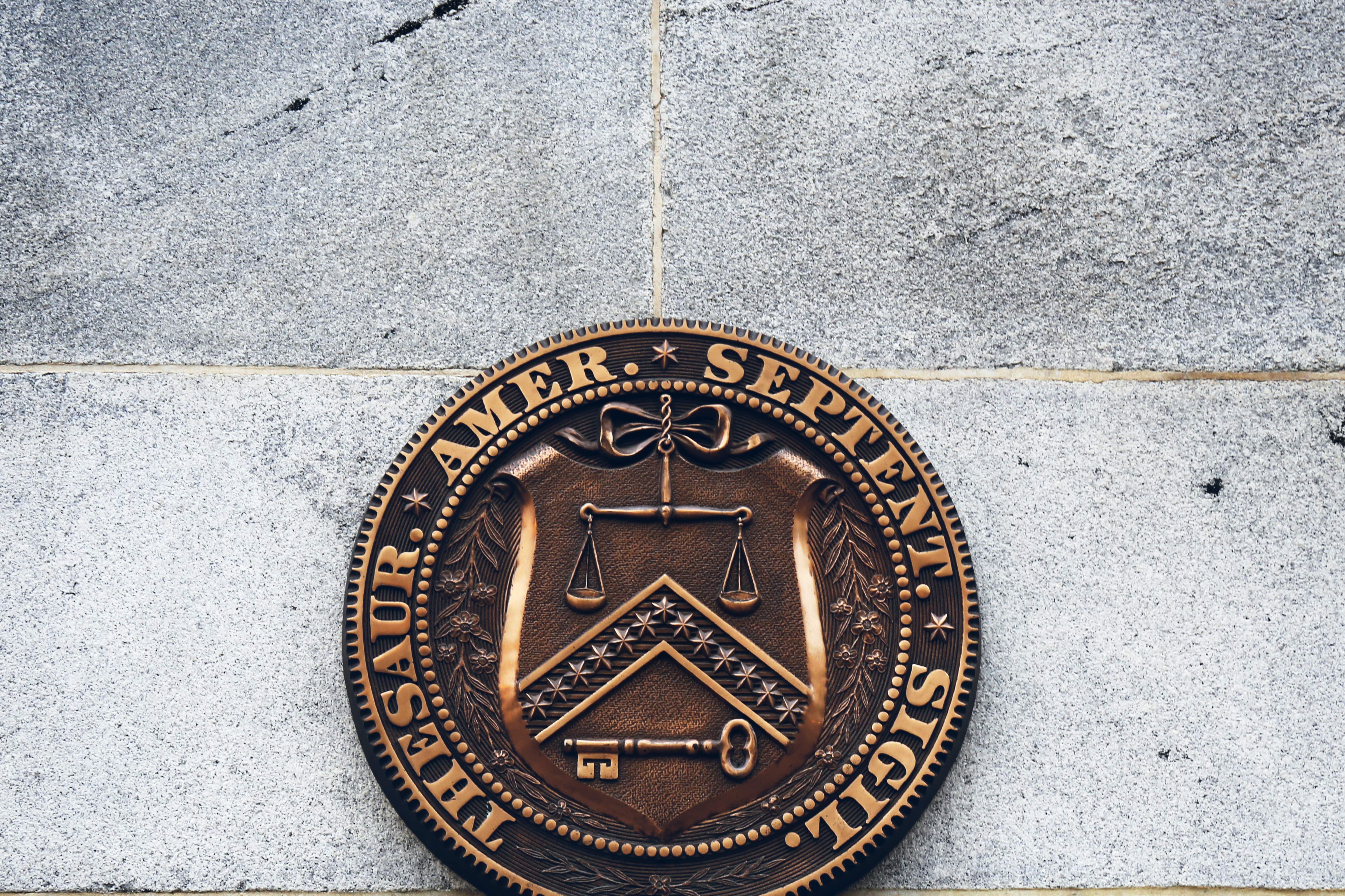 Picture of the seal of the U.S. treasury department on a stone building