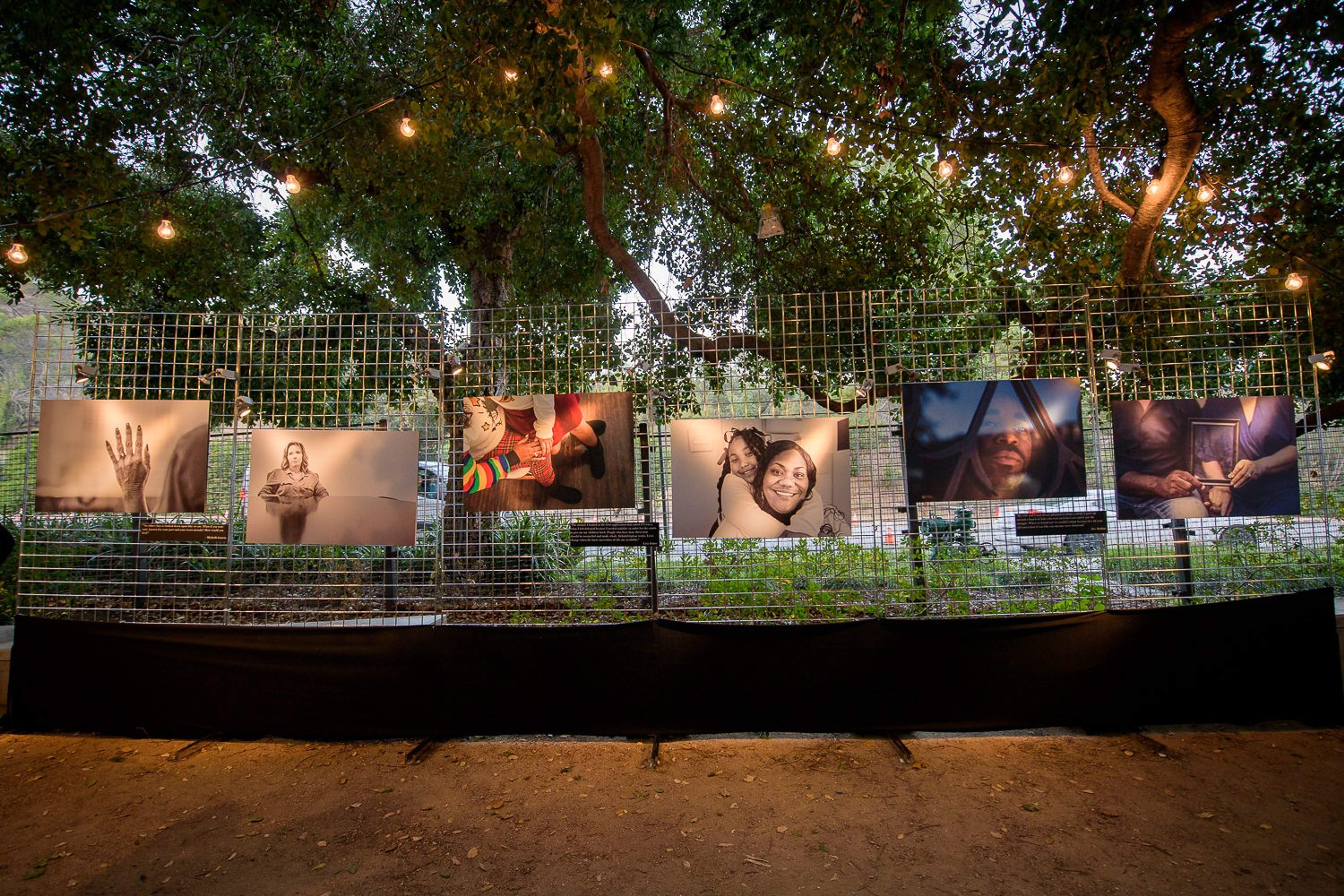 Photos of people affected by incarceration posted on a fence.