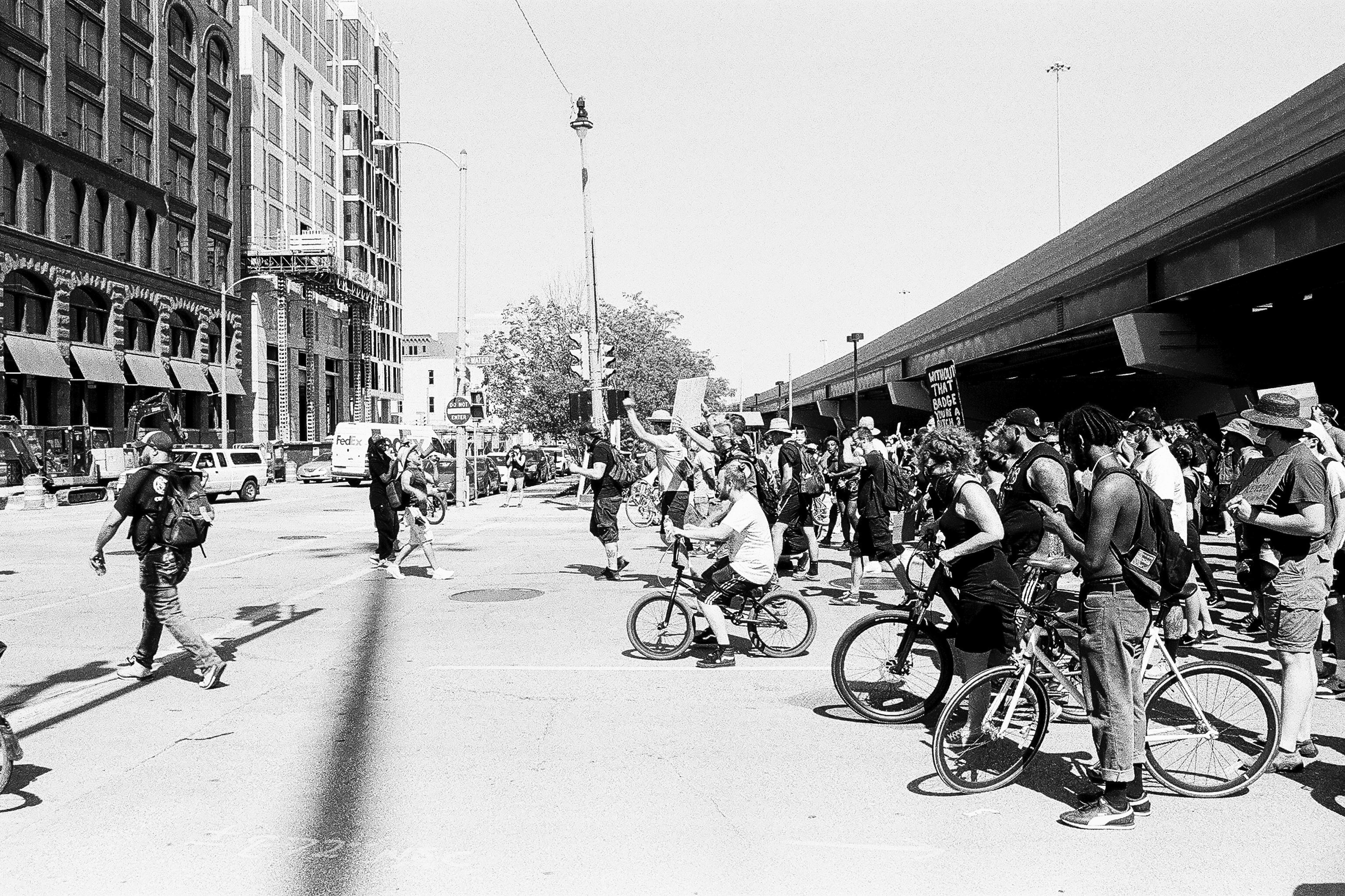 Black and white photo of people protesting police brutality on foot and on bicycles in Milwaukee, Wisconsin