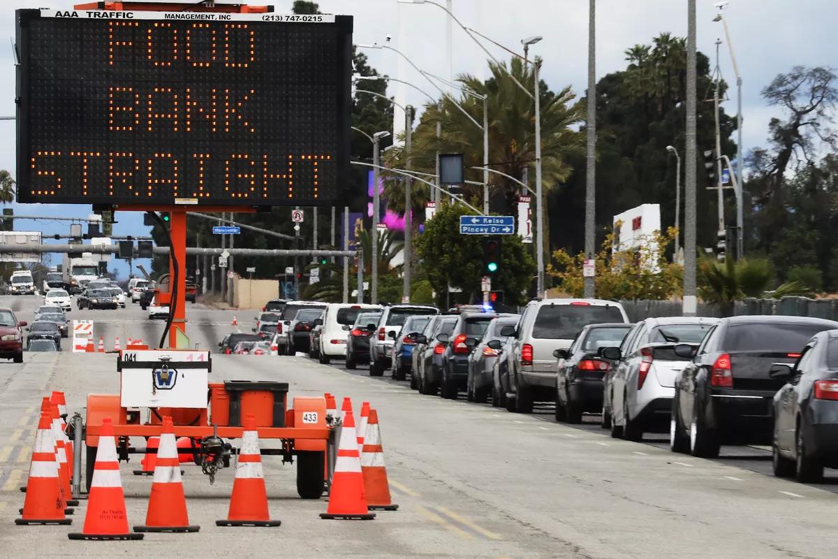 Line of traffic with an advisory sign that reads "food bank straight"
