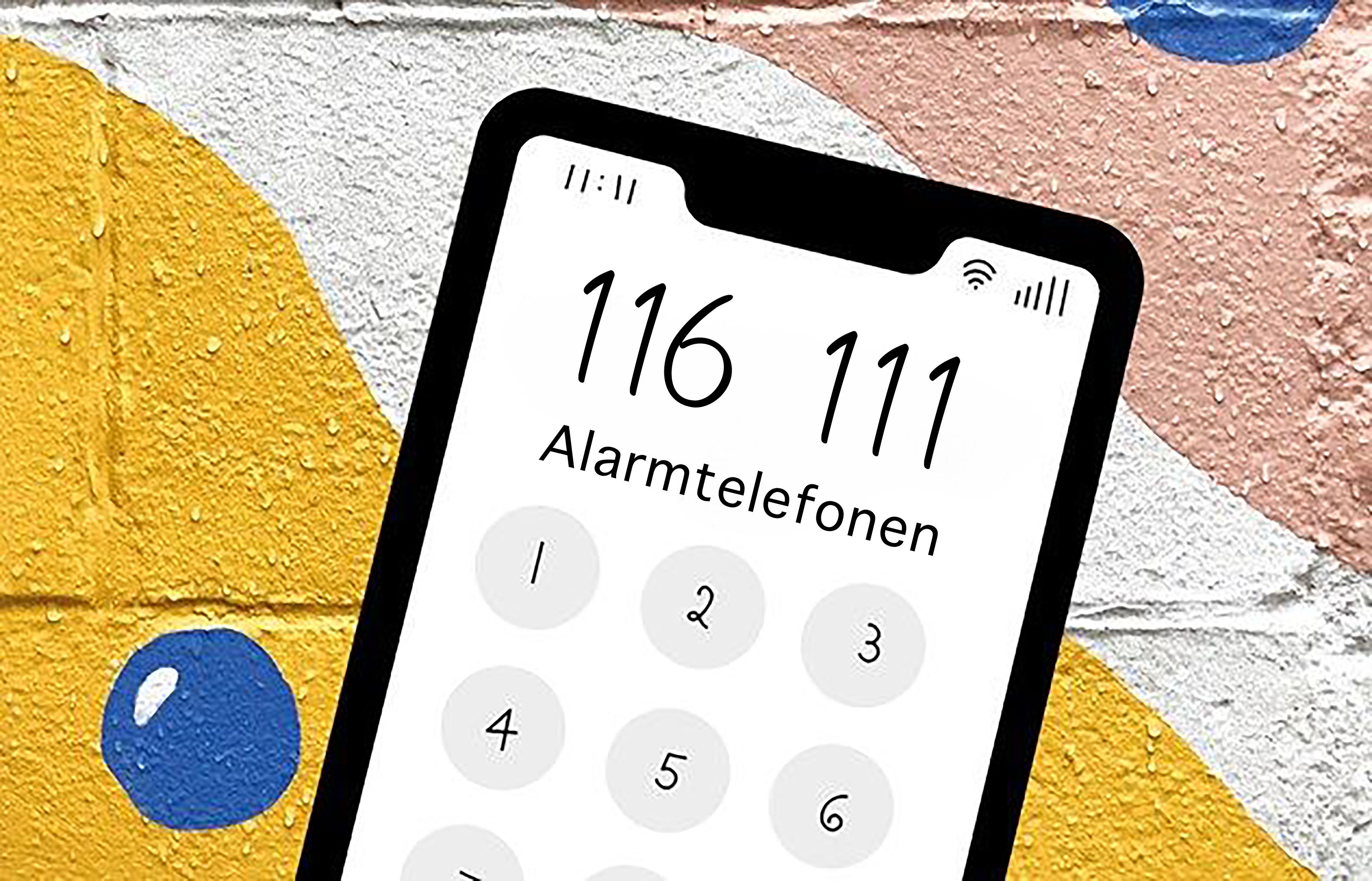 En mobil er foran en murvegg med farger på. På mobilen står det: 116 111 Alarmtelefonen.